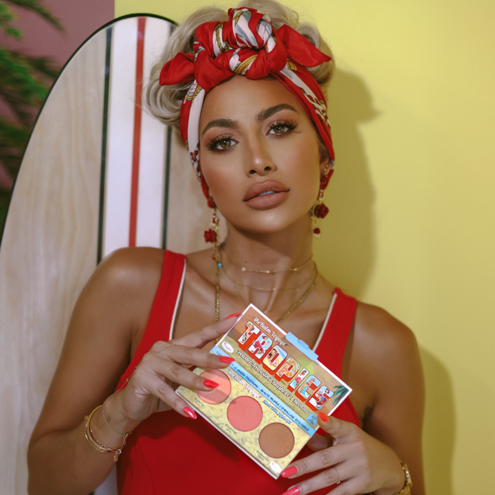Photograph showing TheBalm Voyage Tropics Powder Trio being held by a model