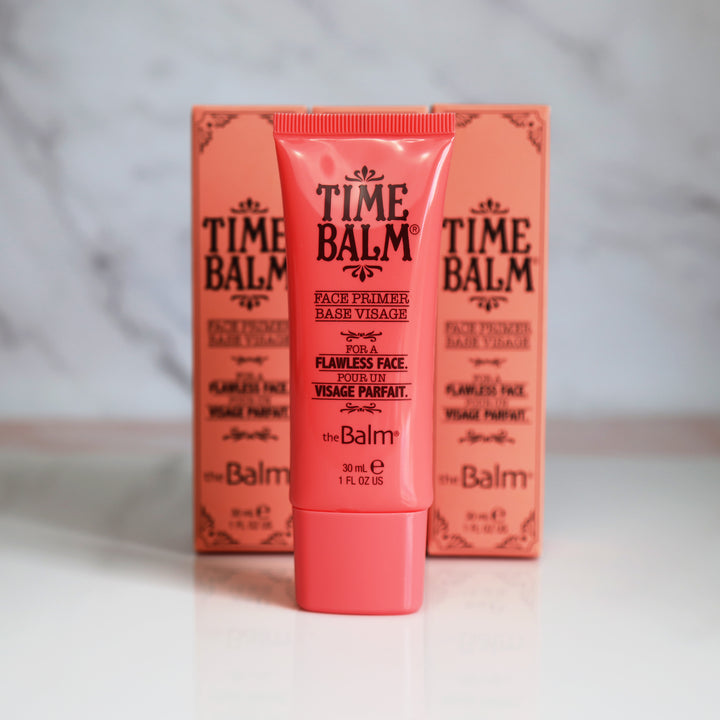 Photograph showing two TimeBalm Primer packages and a makeup tube